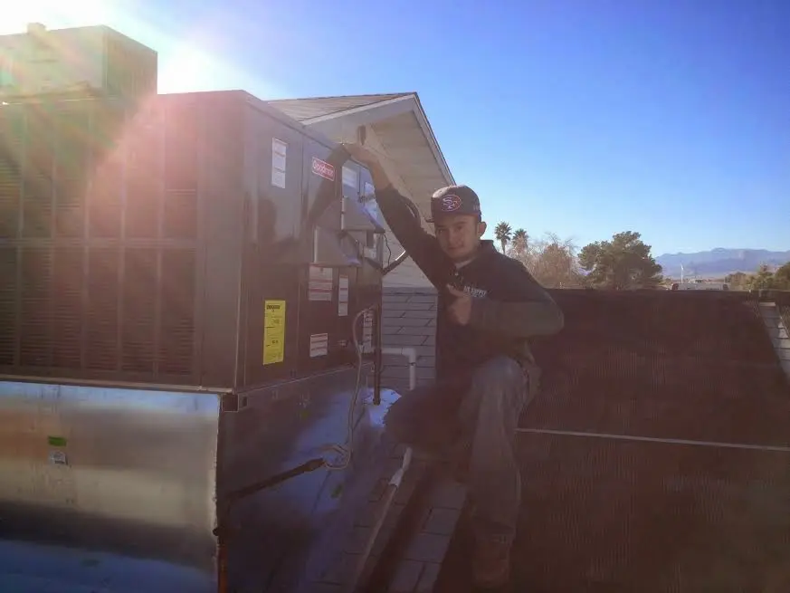 HVAC technician performing Boiler Repair on a rooftop unit in Arroyo Grande